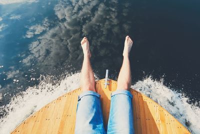 Low section of person relaxing in swimming pool