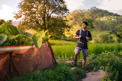 Full length of young man standing against trees