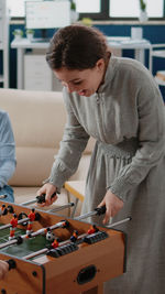 Smiling woman playing foosball at office