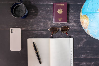 World map and items on wooden background, flat lay. summer travel wanderlust concept, copy space