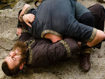 People fighting while lying outdoors