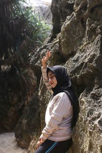 Side view of woman standing on rock