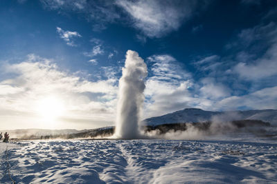 View of waterfall against cloudy sky