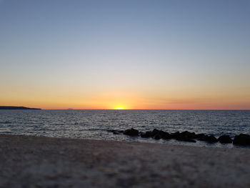 Scenic view of sea against clear sky during sunset