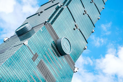 Low angle view of modern building against cloudy sky