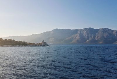 Scenic view of sea and mountains against clear sky