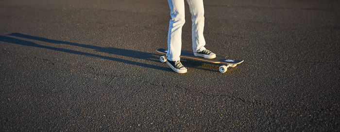 Low section of man standing on road