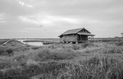 Abandoned house on field against sky