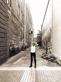 Rear view of man standing on sidewalk in city