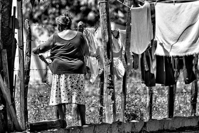 Woman hanging laundry on barbed wire fence