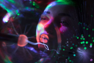 Close-up of woman seen through illuminated bulb by fiber optic in nightclub