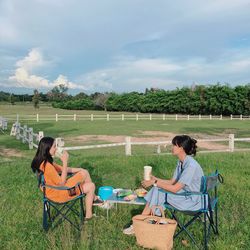 Woman sitting on chair in field
