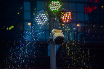 Illuminated lights on wet street at night