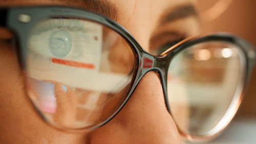 Reflection in glasses of the hands and credit card making e bank online payment. 