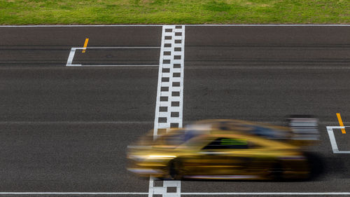Race car blurred motion crossing the finish line on international circuit speed track, motion blur.