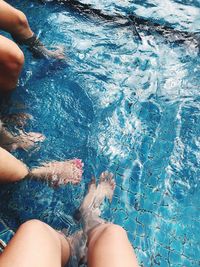 Low section of woman legs in swimming pool