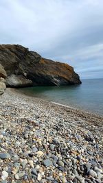 Rocks on beach against sky