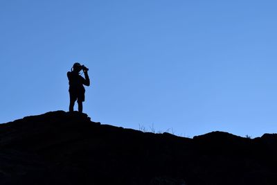 Low angle view of woman standing against clear sky