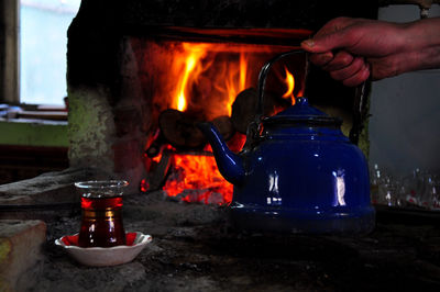 Man holding burning candles on barbecue grill