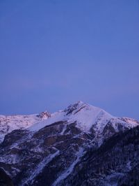 Scenic view of snowcapped mountains against clear blue sky