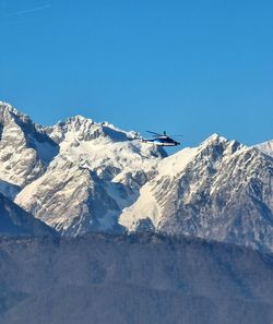 Scenic view of snowcapped mountains against clear blue sky