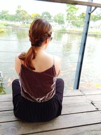 Rear view of woman sitting outdoors