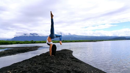 Woman standing on lake against sky