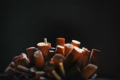 Close-up of cigarette butts against black background