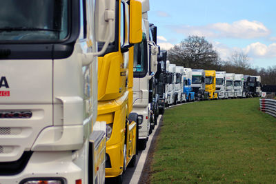 Vehicles in row on road against sky