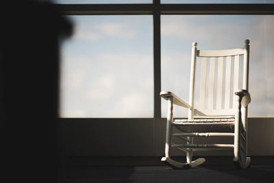 Empty chairs at home against sky