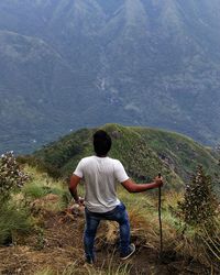 Rear view of man standing on mountain