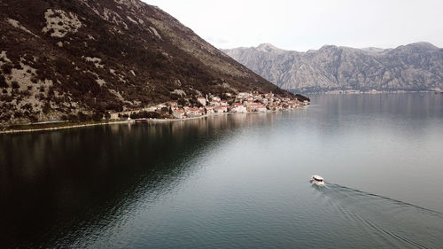 Scenic view of lake by mountains against sky