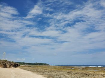 Scenic view of road by sea against sky