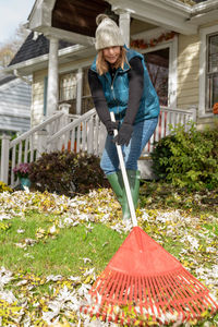 Woman with umbrella standing against plants