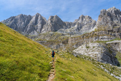 Rear view of man walking against mountain