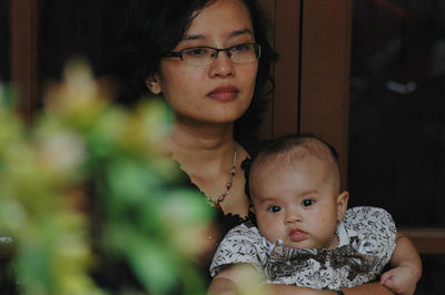 Portrait of young mother hugging baby