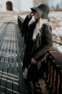 Full length of woman standing on bridge in front of church 