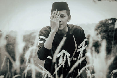 Portrait of young man sitting on field