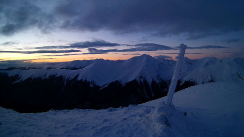 Scenic view of snow covered mountains against sky during sunset