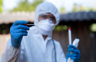 The doctors in the ppe  congestion swab covid from a person to test  coronavirus covid-19 infection.