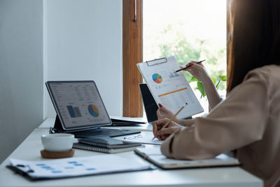 Midsection of man using laptop at office