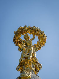 Low angle view of statue against blue sky