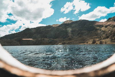 Scenic view of lake by mountains against sky