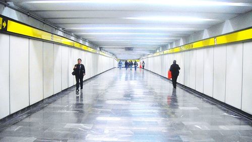 People walking in illuminated tunnel