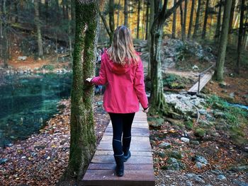 Rear view of woman walking in forest