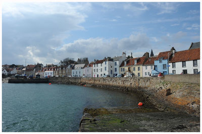 Town by sea against sky