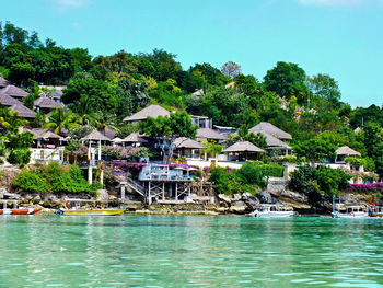 Houses by swimming pool by lake against sky