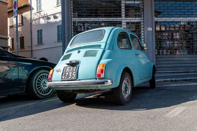 Side view of car on street against buildings