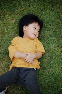 Portrait of boy sitting on grassy field