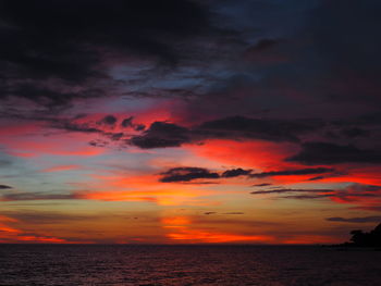 Scenic view of sea against dramatic sky during sunset